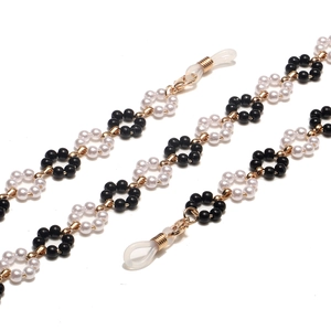 Handmade black and white flower beaded eyewear chain with gold rings and silicone loops