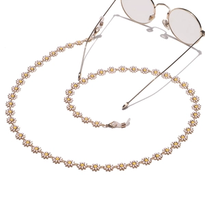Handmade gold eyewear chain with white daisy pendants and non-slip silicone loops