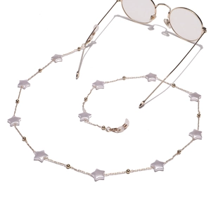 Golden eyewear chain with star charms and beads for sunglasses, shown with glasses