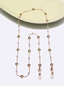 Elegant gold eyeglasses chain with white pearls and silicone loops on ceramic tray