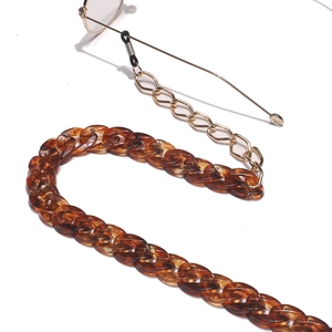 Amber acrylic and gold metal chain for glasses with anti-slip rubber loops on white background