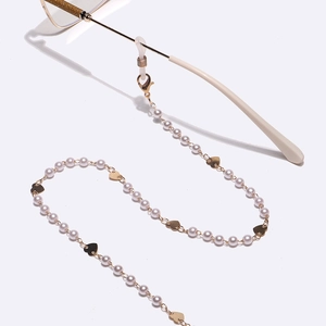 Elegant gold metal glasses chain with heart charms and white pearls on minimal frames