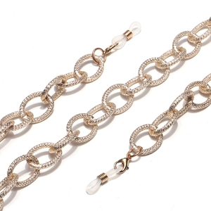 Golden matte metal eyewear chain with textured oval links and clear silicone loops