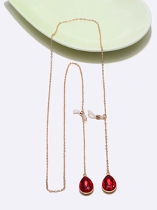 Golden metal eyewear chain with elegant red teardrop pendants on a white background