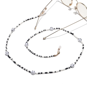 Close-up of mixed black and white seed bead eyeglass chain with smiley face charms