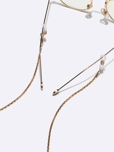 Golden woven eyewear chain set with silicone loops on gold-rimmed glasses