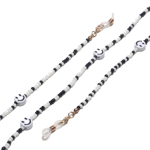 Detail of black and white seed bead glasses chain with smiley faces and gold lobster clasps