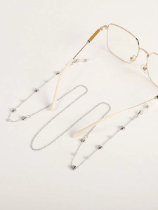 Détail de chaîne de lunettes argentée avec cœurs et perles sur monture dorée