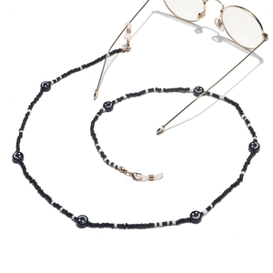 Detail of beaded glasses chain with black and white smiley face beads and gold lobster clips