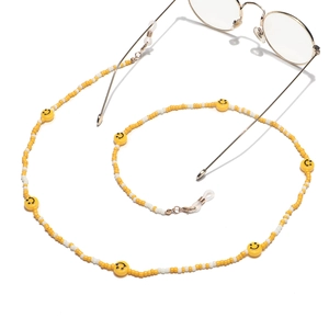 Detail of yellow and white seed bead eyewear chain with smiley faces and gold-toned clips