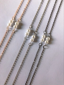 Detail of minimalist pearl eyeglass chains in gold, silver and gun black finishes