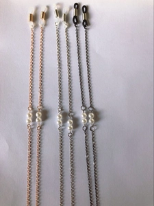 Detailed view of pearl eyewear chains in rose gold, silver, and black metal finishes
