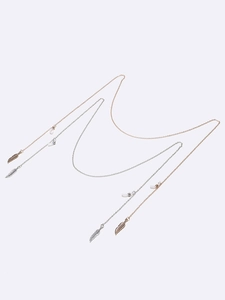 Close-up of gold and silver eyeglass chains with feather charms and silicone loops