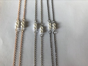 Detailed comparison of three minimalist pearl eyeglass chains in gold, silver, and black finishes