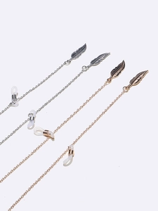 Gold and silver metal eyewear chains with hollow leaf charms on a clean white background