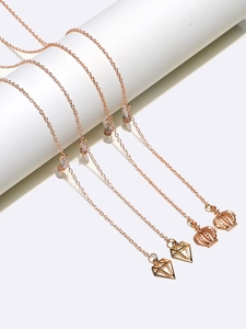 Rose gold glasses chains set with crown and diamond pendants on white display