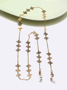 Detailed view of golden fan-shaped hollow charms on the eyeglasses chain strap