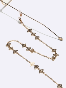 Detail of gold fan-shaped links on metal eyewear chain with clear anti-slip loops