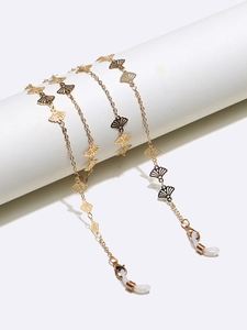 Detailed view of golden fan-shaped charms on eyewear chain with silicone loops