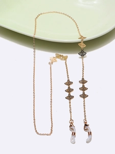 Detail of gold hollow fan-shaped charms on cross chain with white silicone connectors