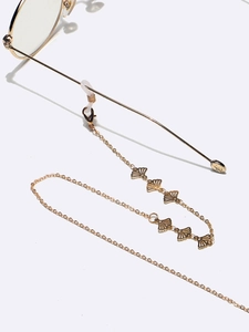 Detail view of golden fan-shaped links on a metal sunglasses chain with silicone loops