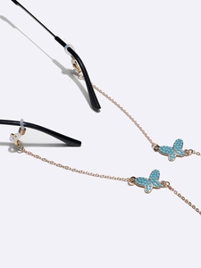Golden butterfly eyeglass chain set with blue bead accents on a minimalist white background