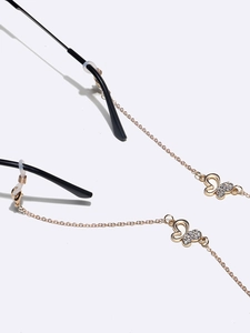 Golden butterfly eyewear chain with sparkling rhinestones shown on black glasses frames