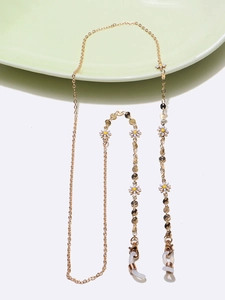 Detail of gold glasses chain with white daisy charms and round metallic pendants