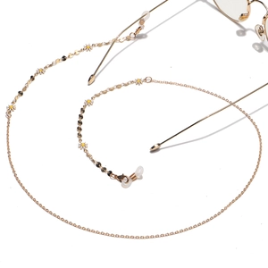 Golden daisy floral metal eyewear chain with white petals and round charms on glasses