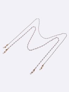 Chaîne à lunettes dorée avec perles de riz lavande et fermoirs mousqueton sur blanc