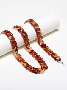 Minimalist amber tortoise shell acrylic eyewear chain on white cylindrical prop