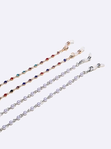 Set of four gold and silver glasses chains with pearls and rhinestones on white background