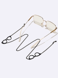 Detail of a black metal eyeglass chain with small glasses pendants on gold frames