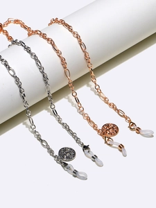 Detail of life tree pendants on gold and silver metal eyewear chains with rubber loops