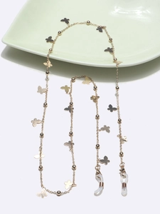 Elegant gold butterfly glasses chain with beads on a ceramic plate with white background