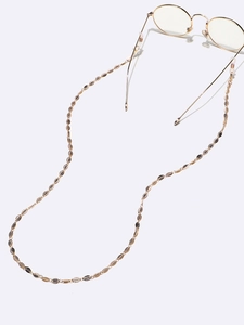 Elegant gold leaf link eyewear chain with rubber loops shown on glasses