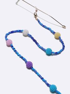 Detail of colorful beads on blue chain with gold lobster clasp and eyeglass loops