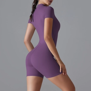 Detailed close-up of dark purple short sleeve yoga bodysuit with premium athletic fabric