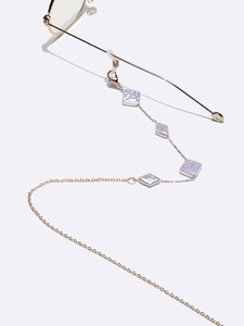 Golden eyewear chain with purple geometric pearl accents on glasses, top view
