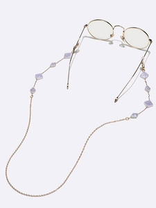 Golden metal eyewear chain with lavender square pearls shown on round wire glasses