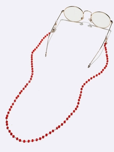 Macro shot of red crystal beads on gold chain with secure rubber eyewear connectors