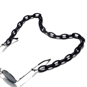 Detail of matte black acrylic chain links attached to eyewear as a stylish glasses strap