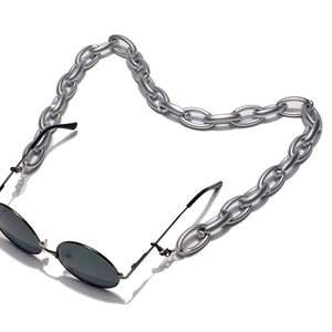 Close-up of black round sunglasses with chunky matte silver metal chain strap