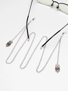 Detailed view of silver metal eyewear chain featuring vintage owl charms and silicone grips