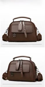 Detail view of coffee leather handbag featuring lychee texture and adjustable striped strap