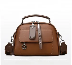 Detailed close-up of orange textured leather handbag with metal kangaroo pendant and strap