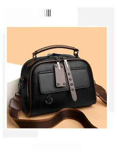 Detail of black lychee grain leather handbag with brown trim and kangaroo pendant