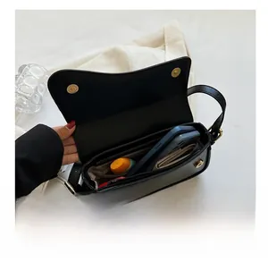 Detail view of internal compartments and magnetic flap closure on black crossbody bag