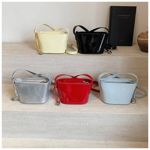 Sacs seaux en cuir de cinq couleurs avec breloques cœur en métal sur marches de pierre