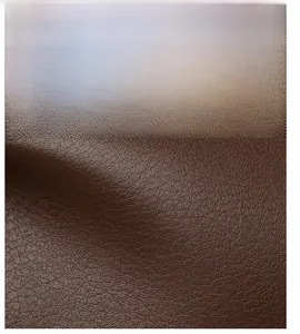 Close-up of deep brown leather with premium lychee grain texture and subtle gloss finish